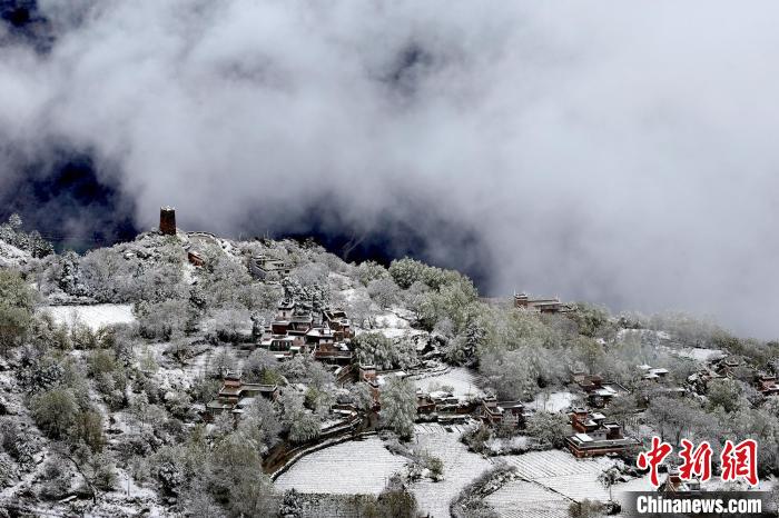 雪后的藏寨和碉樓構(gòu)成美麗的雪景?！〗党鯘衫?攝