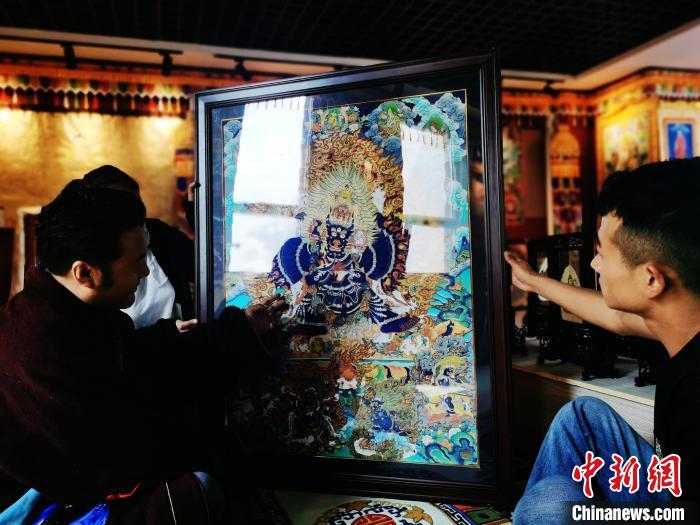 圖為久美尖措(左)與徒弟們展示唐卡作品。　張?zhí)砀?攝