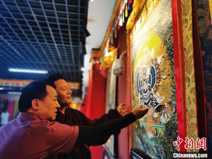 圖為久美尖措展示唐卡作品。　張?zhí)砀?攝
