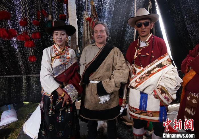 圖為一名外籍?dāng)z影師(中)身穿藏服和藏族民眾合影留念?！●R銘言 攝