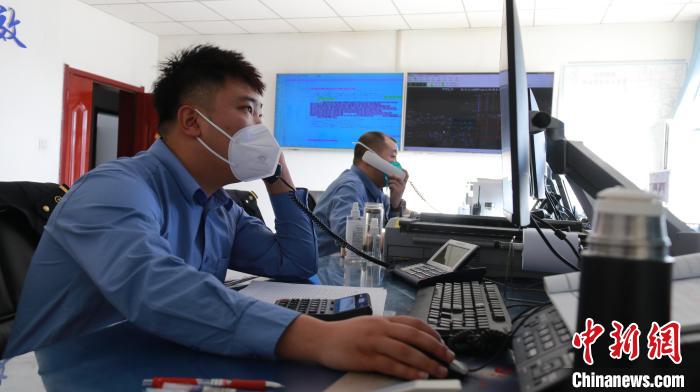 圖為貨運(yùn)調(diào)度人員與外勤工作人員聯(lián)系掌握車輛裝載情況?！±钌?攝