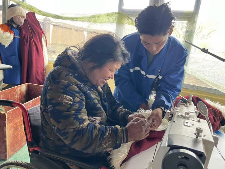 扎西奪爾登幫助殘疾員工裁剪。阿壩州文明辦供圖