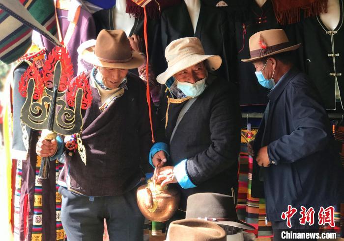 圖為三位藏族老人在集市上聊天交談?！∪轿木?攝