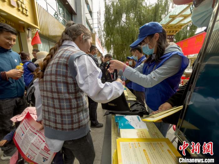 圖為志愿者為市民發(fā)放網(wǎng)絡(luò)安全宣傳手冊?！≈x牧 攝