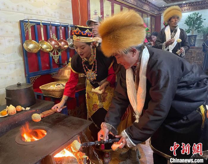 圖為人們?cè)诨鹕峡竟?jié)日美食“結(jié)達(dá)”。　冉文娟 攝