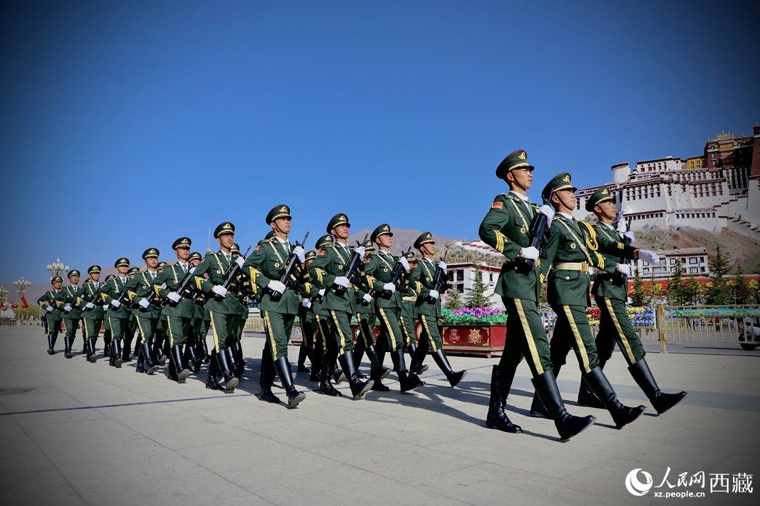 國(guó)旗護(hù)衛(wèi)隊(duì)隊(duì)員緊握鋼槍，踏著威武雄壯的步伐，走向國(guó)旗臺(tái)。人民網(wǎng) 次仁羅布攝