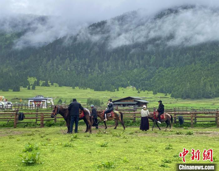 6月10日，游客在魯朗小鎮(zhèn)高山牧場景區(qū)體驗(yàn)騎馬。　冉文娟 攝