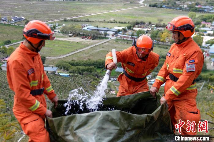 技能大練兵過程中，消防員在陡坡上向蓄水池注水?！±顕鵂c 攝