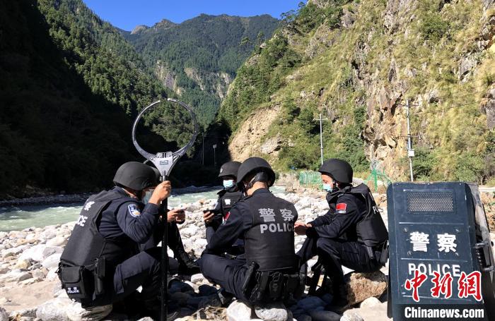 圖為西藏吉隆出入境邊防檢查站移民管理警察在中尼邊境巡邏途中收看二十大開(kāi)幕直播。　郭章統(tǒng) 攝