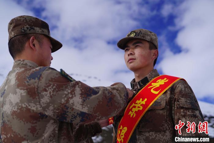 排長(zhǎng)王朝偉(圖左)給退伍老兵佩戴大紅花?！∥鞑厣侥宪姺謪^(qū)某團(tuán)供圖