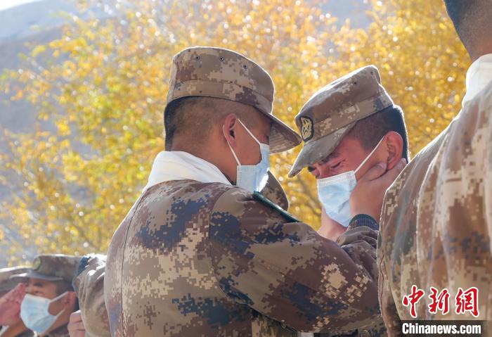 圖為什布奇邊防連退伍老兵與戰(zhàn)友相擁而泣，依依惜別?！⌒觳?攝