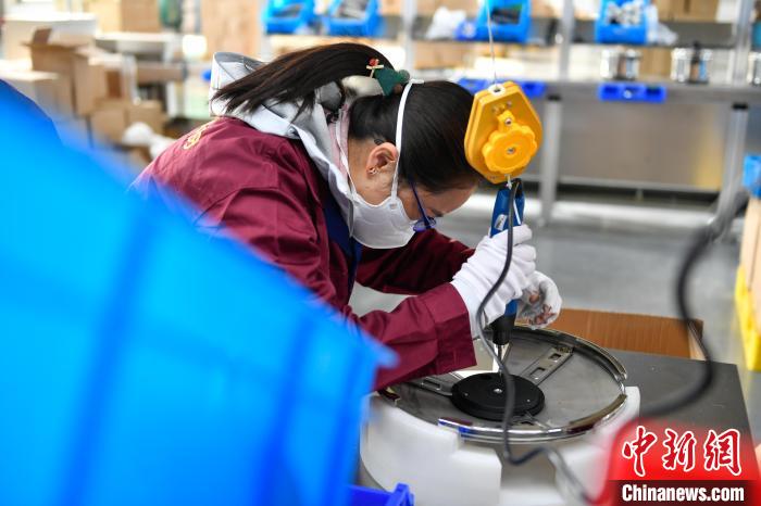 圖為工人正在組裝炊具?！∝暩聛硭?攝