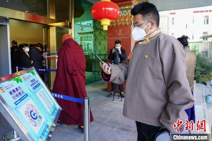 圖為政協(xié)委員掃場所碼進(jìn)入會(huì)場。　江飛波 攝