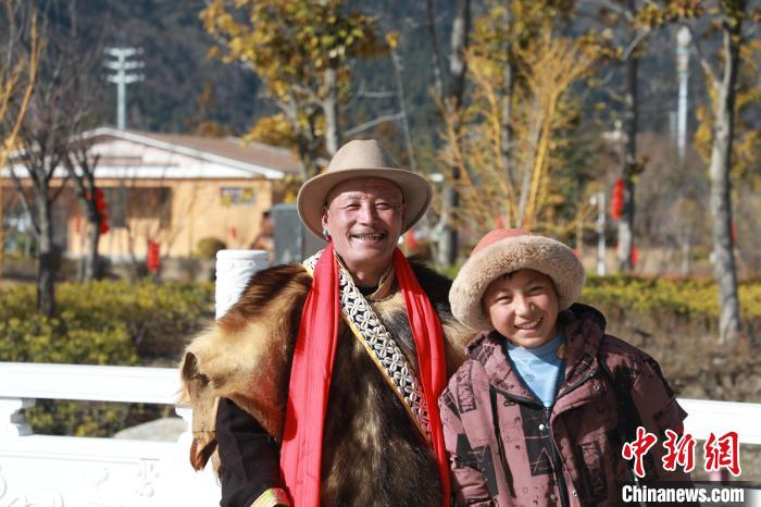 圖為林芝市巴宜區(qū)布久鄉(xiāng)仲果村村民桑杰與孫子一起參加藏歷新年活動?！埩?攝