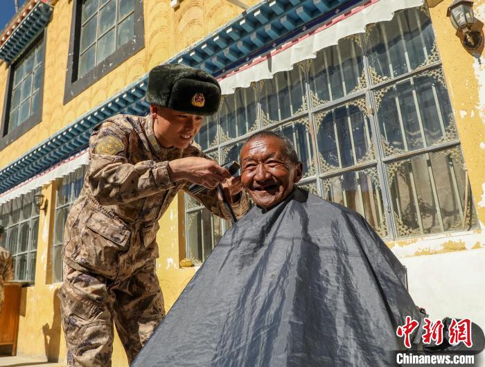 圖為阿里軍分區(qū)某邊防團(tuán)官兵為駐地群眾理發(fā)迎藏歷新年?！〉┰鰝愔?攝