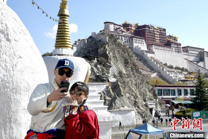 4月17日，游客身著藏式元素服裝在拉薩布達(dá)拉宮觀景臺(tái)拍照留念?！±盍?攝