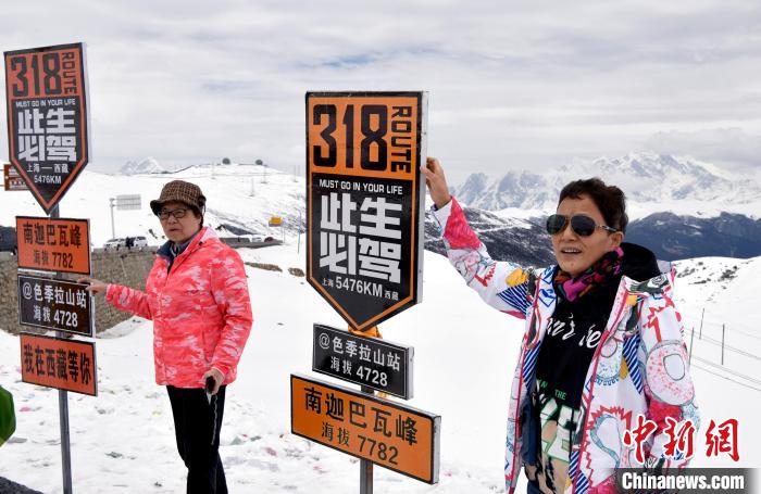 圖為5月14日，西藏林芝色季拉山觀景臺(tái)，游客與南迦巴瓦峰合影?！±盍?攝