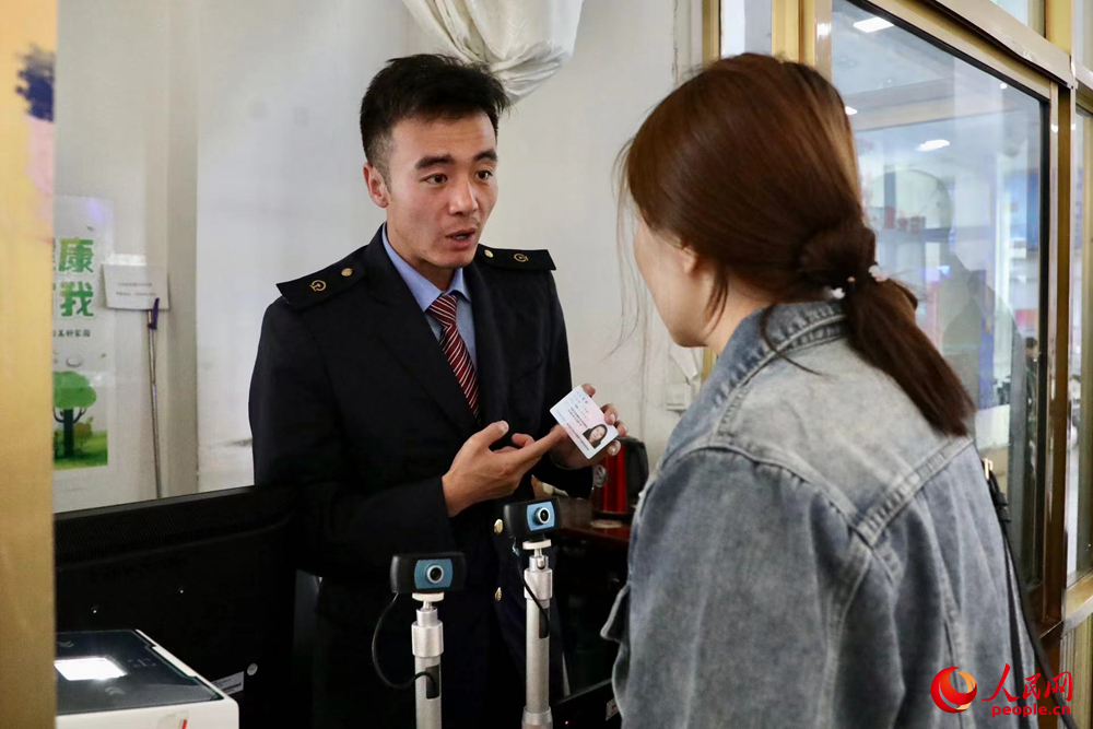 車站工作人員向旅客解答疑問。人民網記者 次仁羅布攝