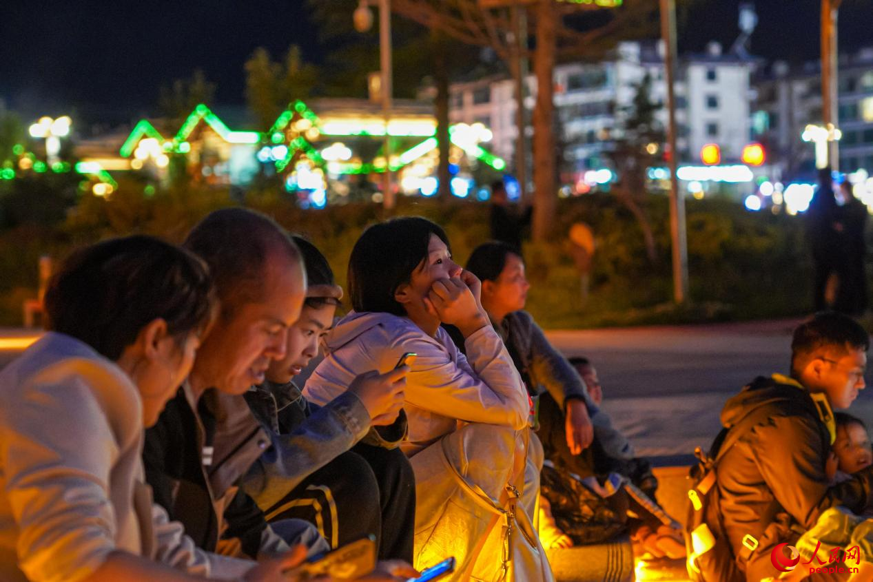 市民坐在西藏林芝市民族團(tuán)結(jié)廣場臺(tái)階上欣賞音樂噴泉。人民網(wǎng)記者 趙晨攝
